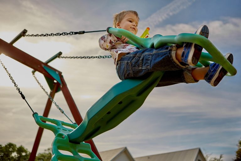 child on park playground swing